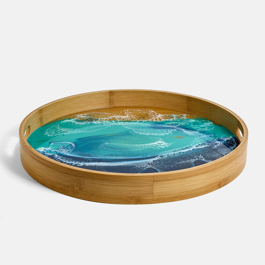 Round wooden tray with a blue ocean abstract design on a white background